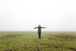 Girl at spring field in fog time.