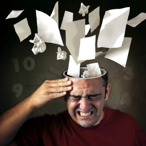 Conceptual image of papers coming out of a mans head with pain expression