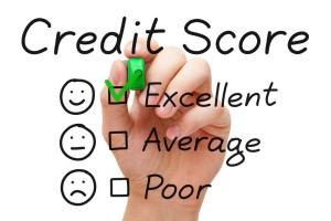 Hand putting check mark with green marker on excellent credit score evaluation form.