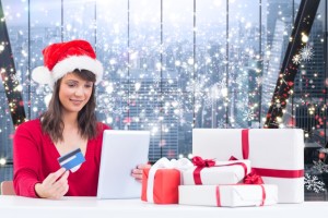 Festive brunette shopping online with tablet pc against glittering lights in room