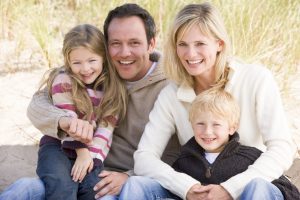 Family sitting on beach smiling