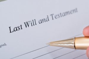 Cropped image of hand signing Last Will and Testament document