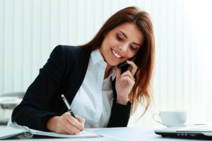 stockfresh_5252485_young-happy-businesswoman-talking-on-the-phone-and-writing-notes-in-office_sizeS-300x200