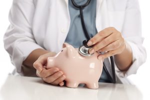 stockfresh_1262970_doctor-holding-stethoscope-to-piggy-bank_sizeS-300x200