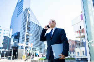 stockfresh_8590344_senior-businessman-calling-on-smartphone-in-city_sizeS-300x200